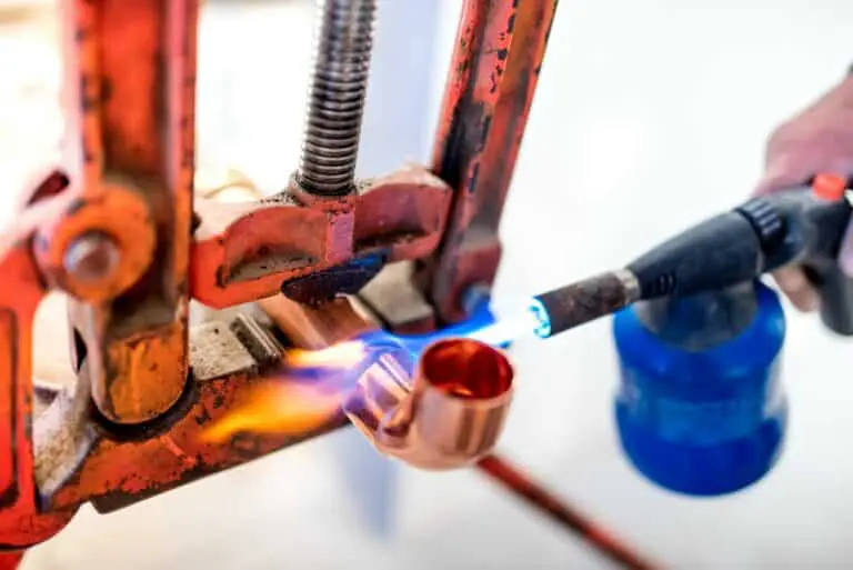 industrial worker using propane gas torch for soldering copper pipes