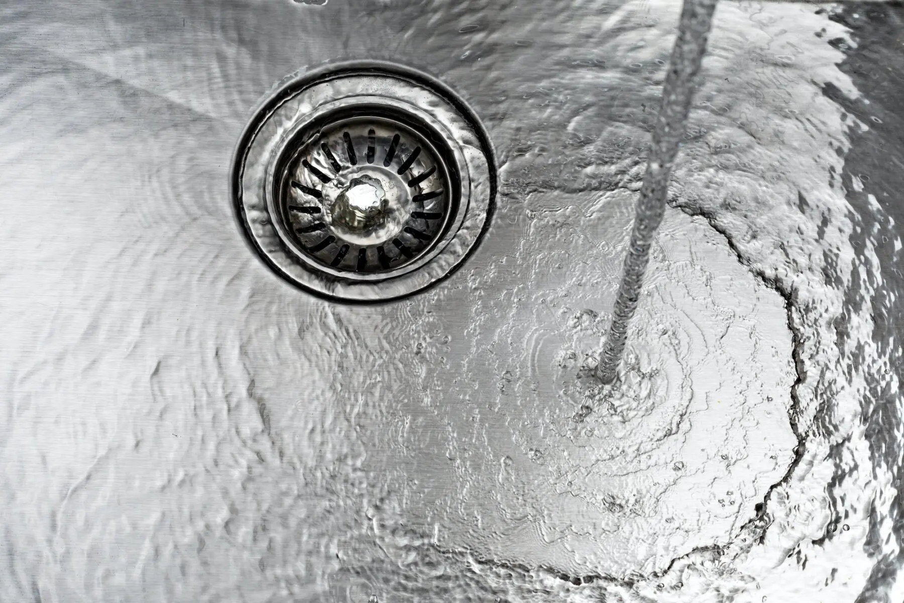 water drains down a stainless steel sink
